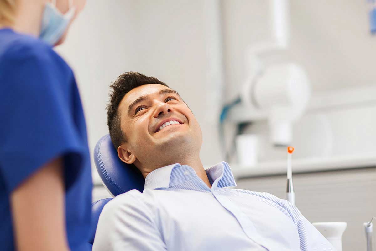man lying back comfortably in the dental chair thanks to sedation dentistry